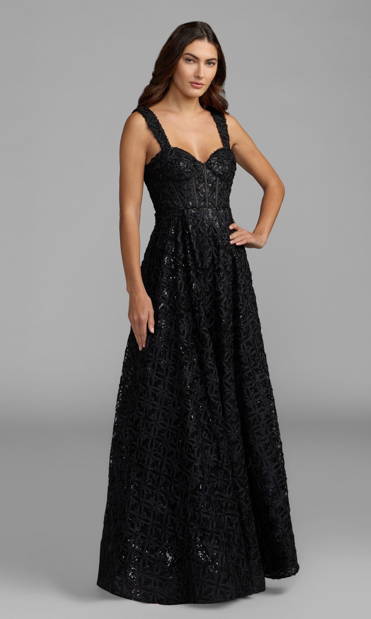 A woman wearing the Mac Duggal 56286 long formal dress in black, featuring textured fabric, stands against a plain gray background.